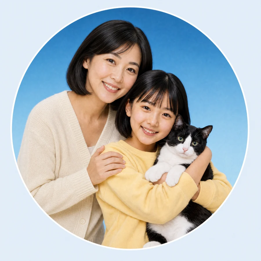 猫を抱く亜希ちゃんの肩に手を添えて微笑むお母さん